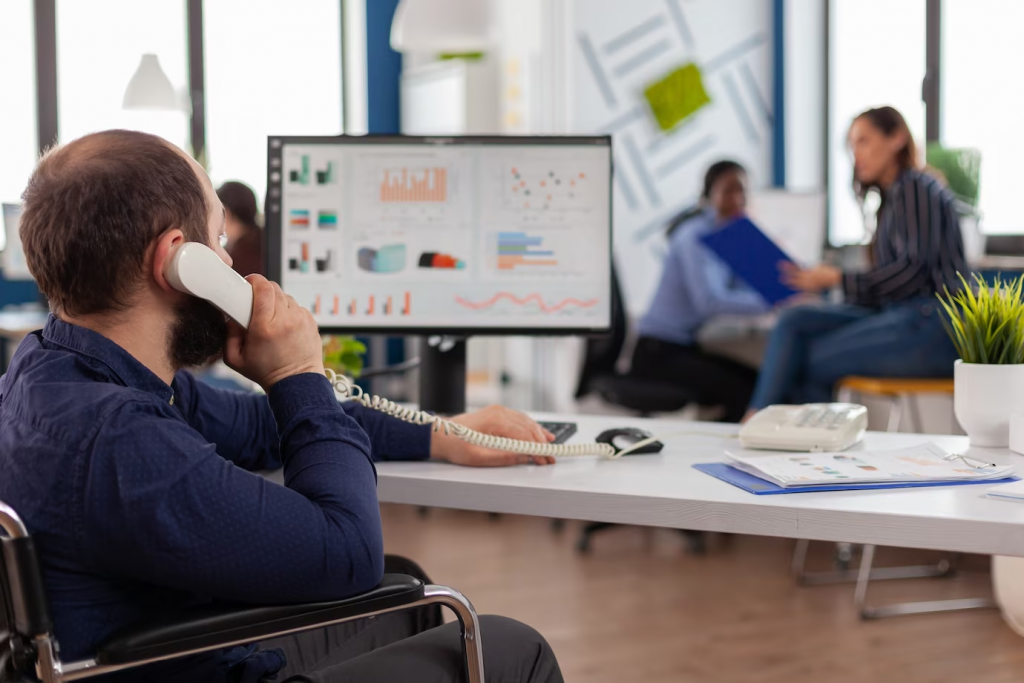 a person is talking on the phone and in front of him is a monitor with analytical information