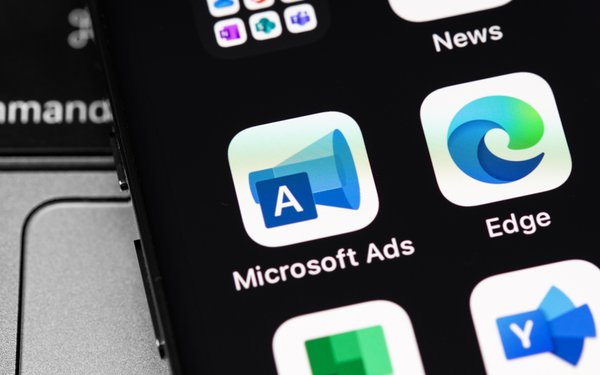 Microsoft Ads mobile icon on a cellphone along with other apps.