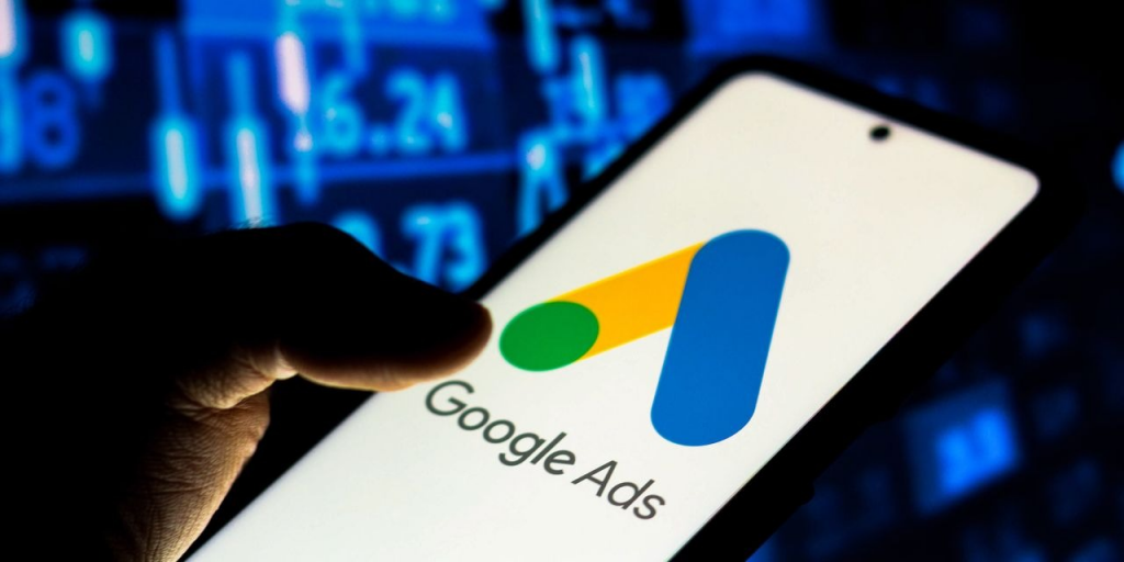 image of a person holding a smartphone displaying Google Ads logo