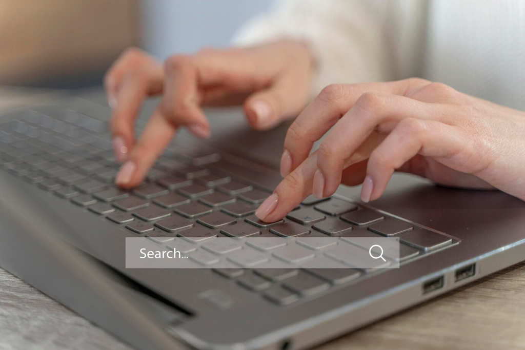 Someone typing on a notebook with a searchbar to illustrating that it's searching for something in the web.