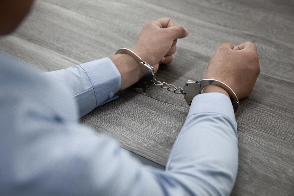 a person in handcuffs showing the effects of illegal SEO negative activities