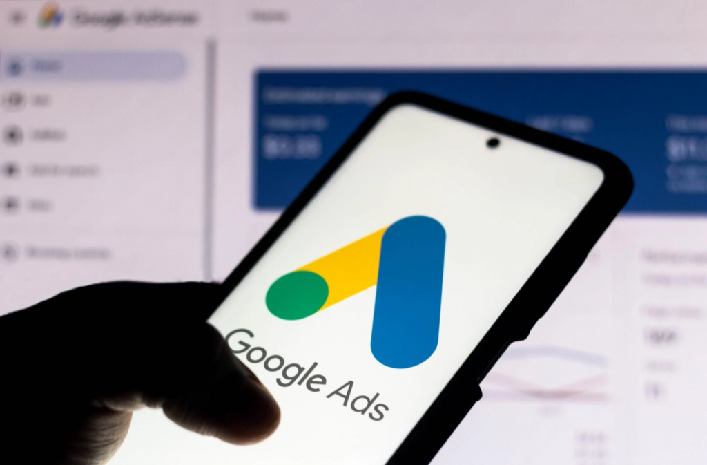 picture of a person holding a phone displaying Google Ads logo