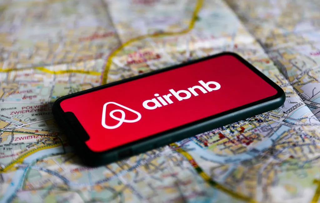 image of a phone on top of a map displaying Airbnb's logo